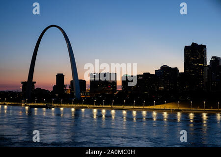With the Gateway Arch standing out against a colorful sunset, the St. Louis skyline is seen over the Mississippi River Stock Photo