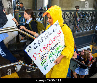 New York, USA,  20 September 2019.  A woman on a chicken costume and carrying a sign against Cargill  arrives in the subway to join a  Climate Strike rally in New York city. Tens of thousands joined the global protest to demand immediate action to fight climate change. Credit: Enrique Shore/Alamy Live News Stock Photo