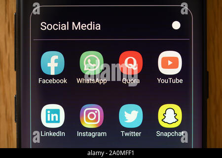 Social media apps on a smartphone screen in a folder Stock Photo