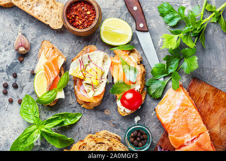 Open sandwich with salmon and vegetables.Small sandwiches.Toasts with salted salmon Stock Photo