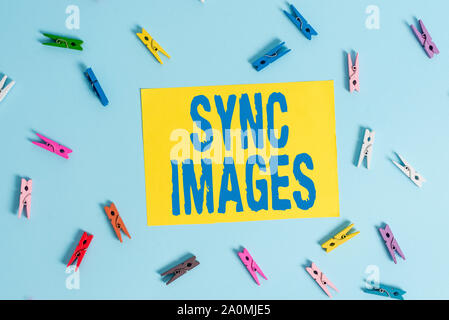 Handwriting text Sync Images. Conceptual photo Making photos identical in all devices Accessible anywhere Colored clothespin rectangle shaped reminder Stock Photo