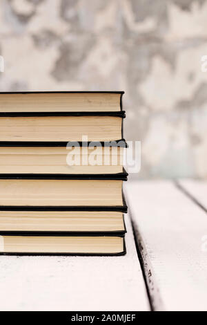 Stack of old ancient shabby books on a white wooden background. Selective focus. Stock Photo