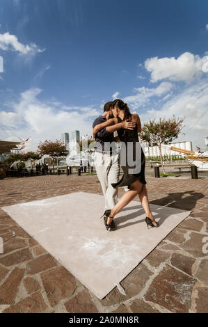 Buenos Aires, Argentina - February 08 2012: A couple dancing tango in the streets of Puerto Madero and waiting for someone to leave a tip. Stock Photo