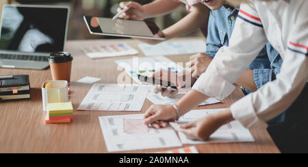 Team of young professional UI graphic designer discussing on their smartphones templates together Stock Photo