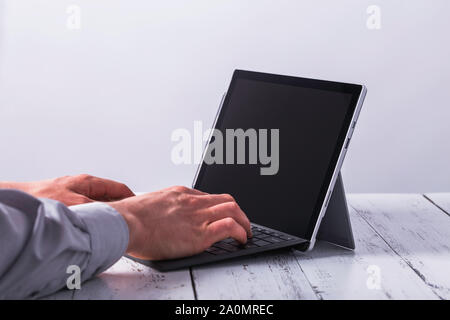 Writing male hands on laptop on the table. Stock Photo
