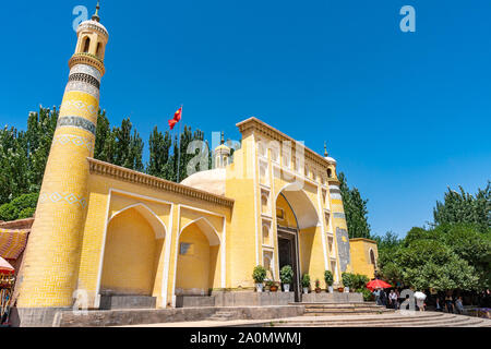 Kashgar Id Kah Mosque with a Waving China Flag on the Top of the Roof and Chinese Tourists on a Sunny Blue Sky Day Stock Photo