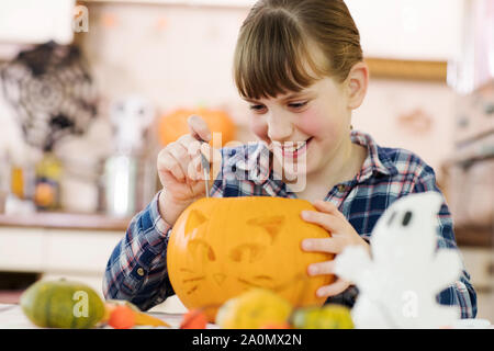 Girl Carving Halloween Lantern From Pumpkin At Home Stock Photo