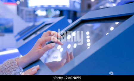 Woman using multimedia touchscreen display of interactive kiosk Stock Photo