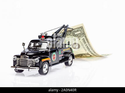 Tow truck towing a US dollar bill – debt recovery concept Stock Photo