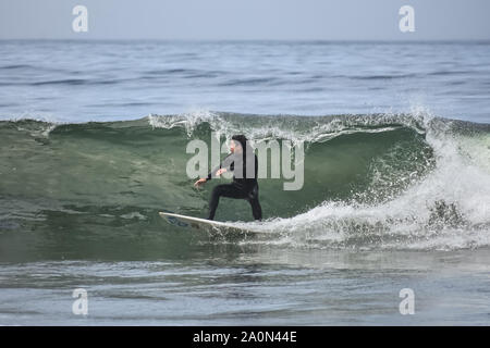 Surfer rides a beach break wave off the coast of Northern California Stock Photo