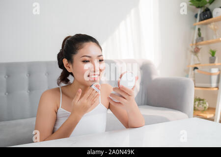 Beautiful young Asian woman using beauty blender for applying foundation for make-up on face. Stock Photo