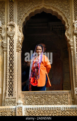 JAISALMER, RAJASTHAN, INDIA, November 2018, Tourist inside the heavily carved window of Kothari's Patwon ki Haveli Stock Photo