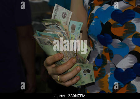 JULY 18, 2019-HO CHI MINH VIETNAM : Woman holding a bunch of Vietnamese dong bills. Vietnamese dong is the money used in Vietnam. Stock Photo