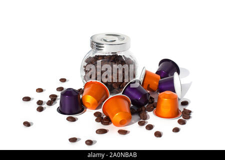 Coffee capsules and coffee beans in a glass jar on a white background isolated  closeup Stock Photo