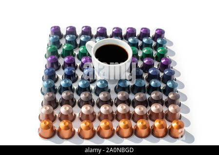 Coffee capsules different kinds and colors on a white background top view isolated in square closeup and cup of back coffee Stock Photo