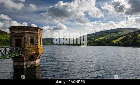 Sun shines on the filter tower of Talybont Reservoir and the surrounding mountains of the Brecon Beacons in South Wales. Stock Photo
