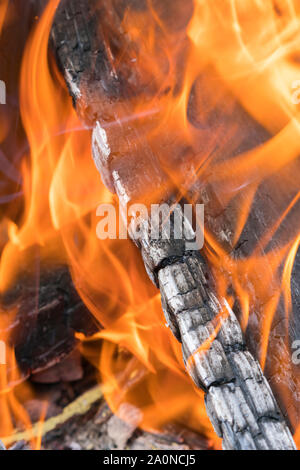 Fireplace burning. Warm cozy burning fire in a brick fireplace close up. Cozy background. Bonfire in nature. Fire background. Vertical photo. Stock Photo