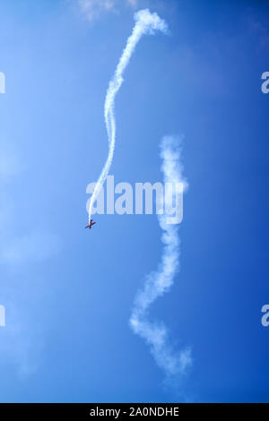 Falling plane on blue sky  background high in the sky, falls down, figure aerobatics The Barrel roll Stock Photo