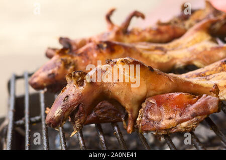 BANOS, ECUADOR - FEBRUARY 28, 2014: Guinea pigs being barbecued for sale on Ambato Street at the market hall on February 28, 2014 in Banos, Ecuador Stock Photo