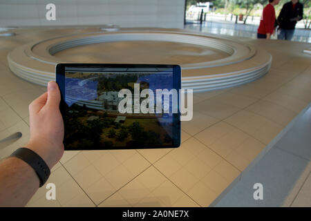 CUPERTINO, CALIFORNIA, UNITED STATES - NOV 26th, 2018: People at the Apple Park Visitor Center in Silicon Valley explore the new Apple Offices using a Stock Photo