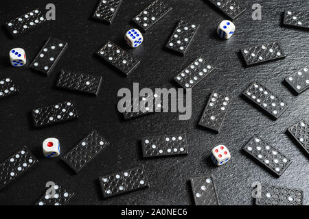 A set of domino bones,dices on black stone background Stock Photo