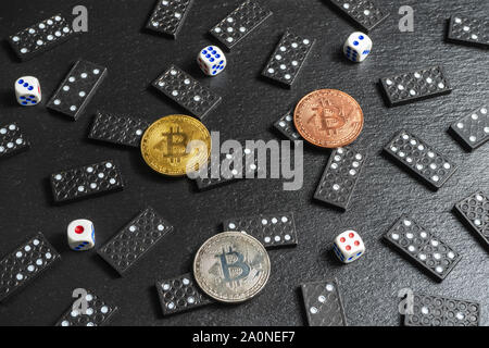 A set of domino bones,dices and bitcoins on black stone background Stock Photo