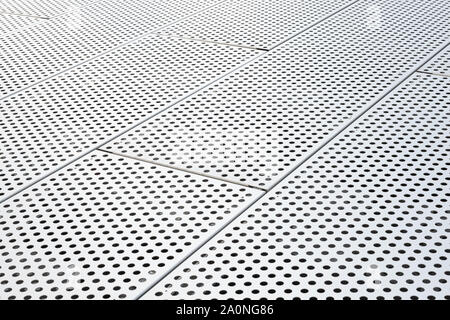 Metal grilles with many round holes in the ceiling background perforated panel. Dot pattern on surface, diagonal view Stock Photo