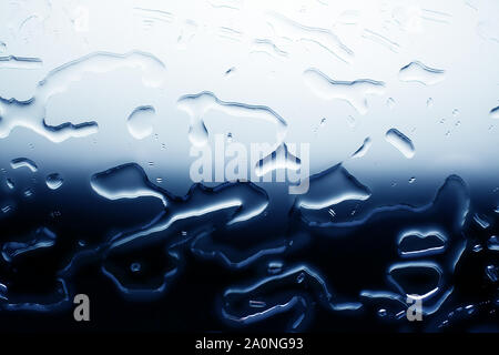 Contrast pattern spilled water texture background, white to dark blue color gradient, water drops on glass surface top view, close up, water blots Stock Photo