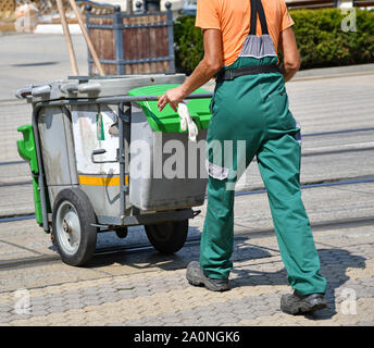 Street cleaner man with wheeled garbage cans Stock Photo