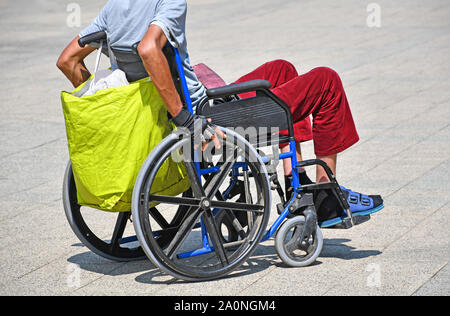 Man in wheelchair on the city street Stock Photo