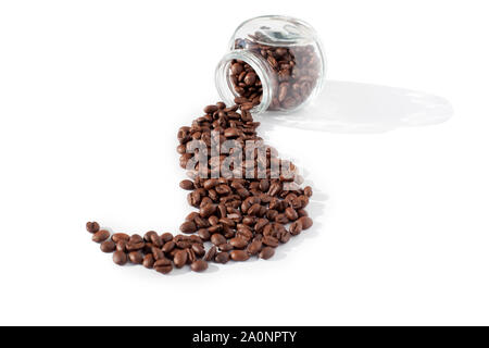 Coffee beans scattered in a beautiful wave from transparent glass jar on a white background isolated close up top view Stock Photo