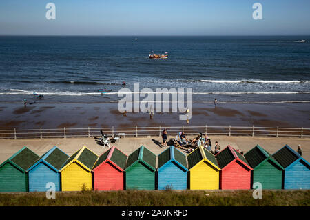 Brightly painted beach huts in Whitby, Yorkshire, as temperatures are expected to soar to 26C in some parts of the country this weekend. Stock Photo