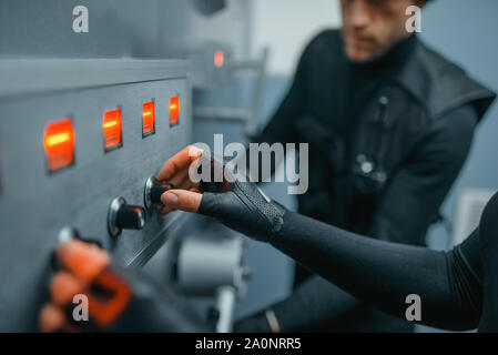 Robbers in black uniform trying to find the code Stock Photo