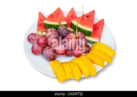 Slices of watermelon, mango and grape fruits on dish isolated on white background, clipping path included Stock Photo
