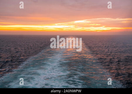 Sunset over the North Sea, and ships wake disappearing into the distance, from the Queen Mary 2 Stock Photo