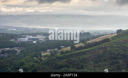 Morning mist hangs over Cerphilly town and GE Aviation facility in the South Wales Valleys as viewed from The Garth Mountain. Stock Photo
