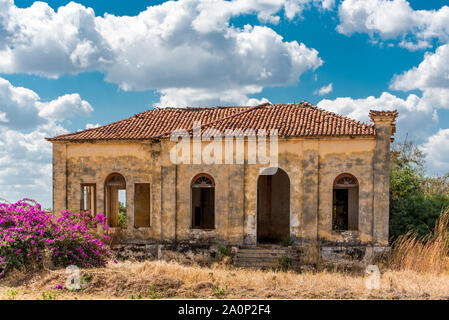 An empty and abandoned house in a grassy field in rural Mozambique, Africa Stock Photo