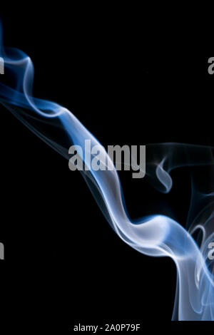 Delicate streak of smoke on black background, delightful aroma Stock Photo