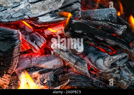 Closeup of burning and smoldering firewood. Close-up of Burning coal. Glowing embers smoldering in the fireplace. Burning log of wood close-up as abst Stock Photo