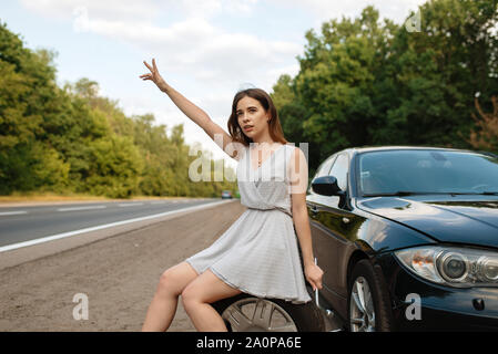 Car breakdown, young woman vote on the road Stock Photo