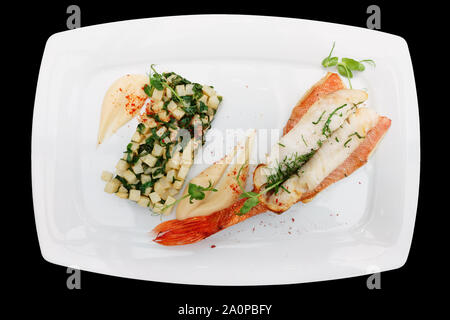Red snapper fillet and fried celery root with potato mash isolated on black background Stock Photo