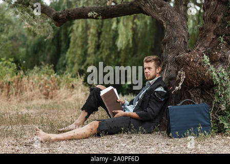 Businessman sitting on the ground, lost island Stock Photo