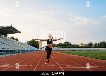 Female jogger in sportswear crosses finish line Stock Photo