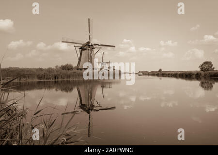 Old windmill on the edge of the lake in sepia tone Stock Photo