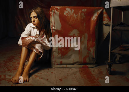 Young female victim in mental hospital basement Stock Photo