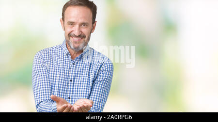 Handsome middle age elegant senior man over isolated background Smiling with hands palms together receiving or giving gesture. Hold and protection Stock Photo