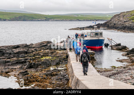 People boarding the Mousa Boat for the ferry  journey back to Shetland Mainland from the island of Mousa. Stock Photo