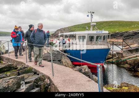 People arriving on the island of Mousa disembarking from the Mousa Boat ferry from Shetland Mainland. Stock Photo