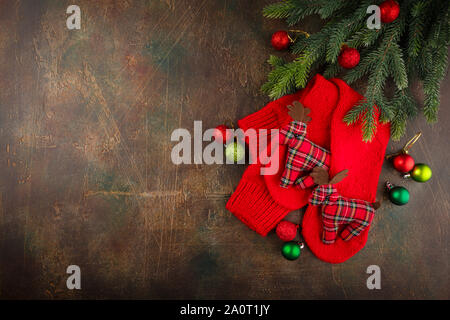 Christmas warm knitted red socks with toy deers. Christmas background with gifts. Copy space, top view, flat lay. Stock Photo