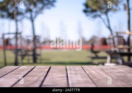 Empty table covered with sackcloth over blurred trees with bokeh background Stock Photo